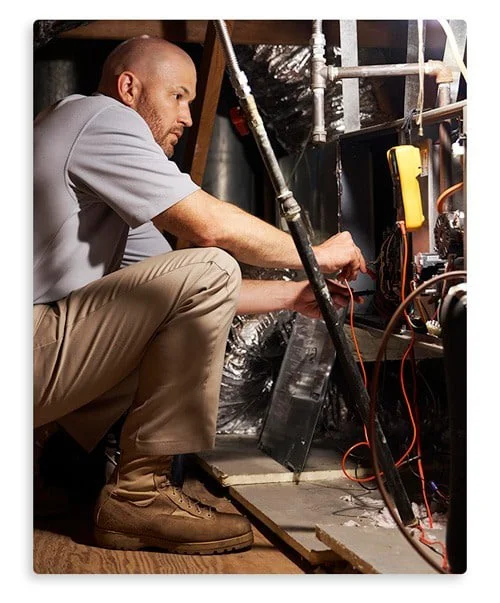 A skilled technician from Environmental Heating & Air Solutions inspects an HVAC system